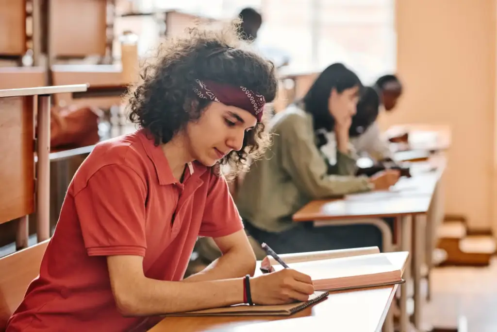 Estudante de faculdade concentrada fazendo uma prova na sala de aula.