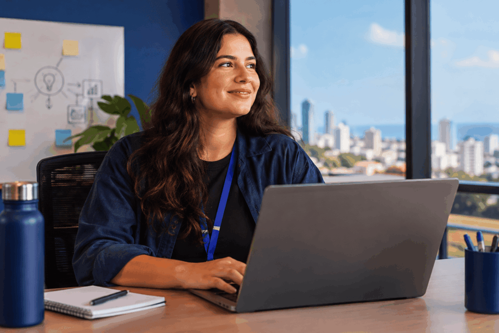 A imagem representa o ambiente dinâmico de uma startup, com uma profissional trabalhando em um escritório moderno. O cenário transmite inovação, autonomia e desenvolvimento de carreira, características do Programa Trainee Praso 2027. A composição destaca a possibilidade de assumir novos desafios e crescer profissionalmente em uma empresa de tecnologia.